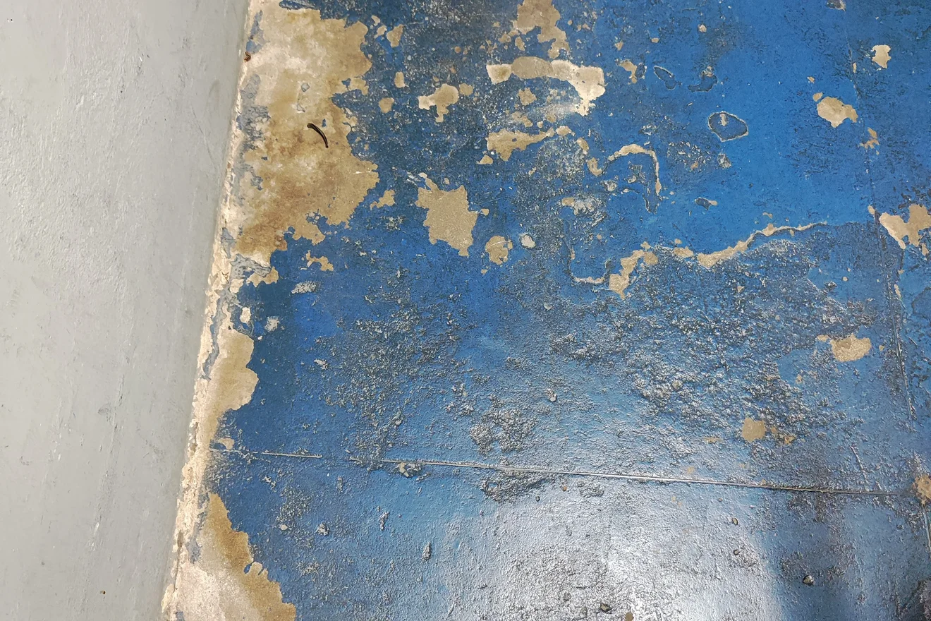 Registro técnico de pintura desgastada e superfície a recuperar.